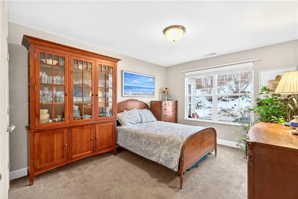 a bedroom with a large bed and windows