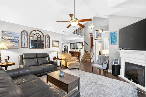 a living room with furniture a fireplace and a flat screen tv