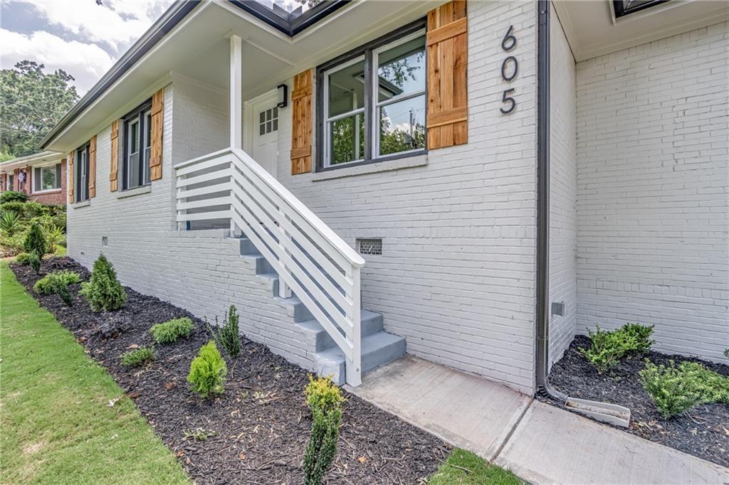a view of a house with potted plants and a wooden fence