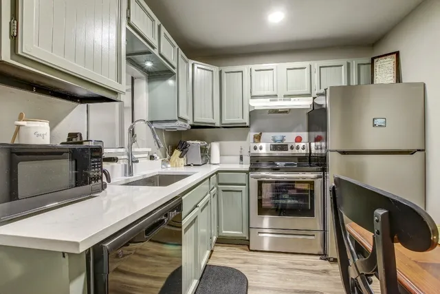 a kitchen with stainless steel appliances granite countertop a sink stove and refrigerator
