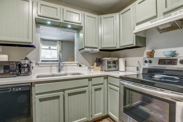 a kitchen with stainless steel appliances granite countertop a sink stove and cabinets