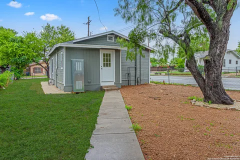 a front view of a house with yard and tree