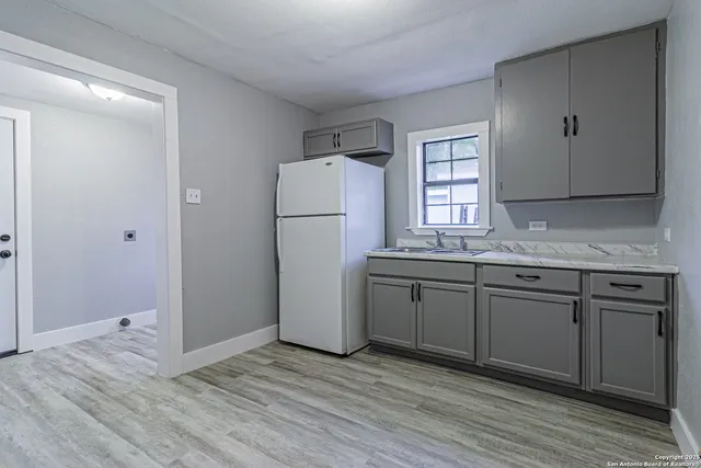 a kitchen with a sink cabinets stainless steel appliances and a window