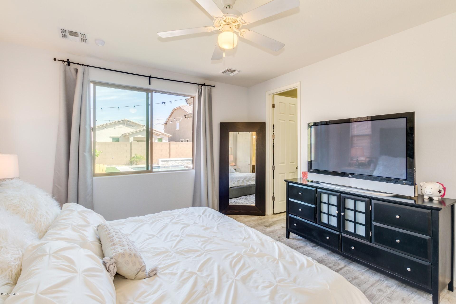 7726 West Shumway Farm Road Laveen, AZ 85339 - Photo 16 of 27 a bedroom with a bed and a flat tv screen on dresser