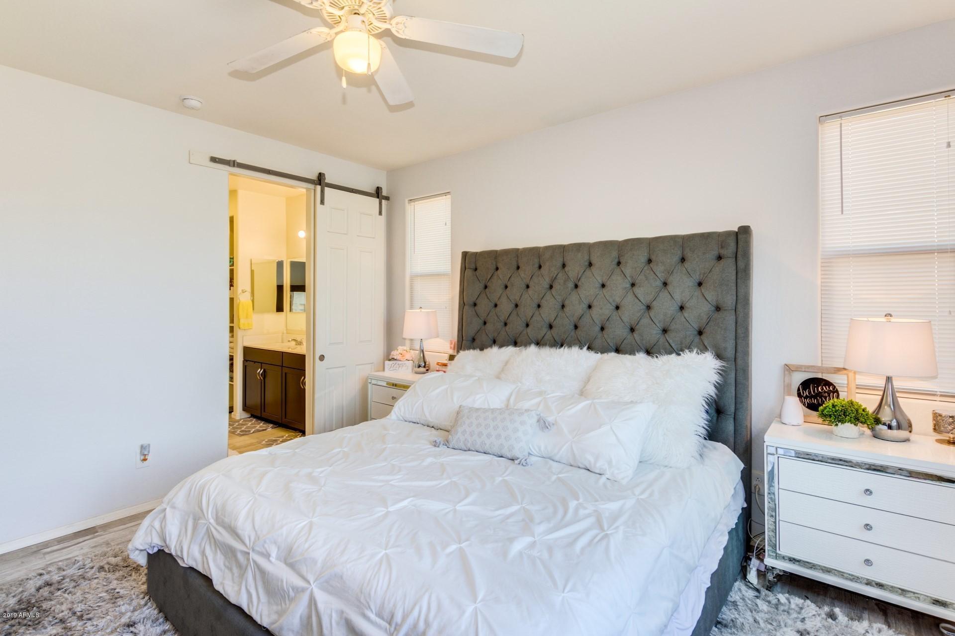 7726 West Shumway Farm Road Laveen, AZ 85339 - Photo 17 of 27 a bedroom with a bed and a chandelier