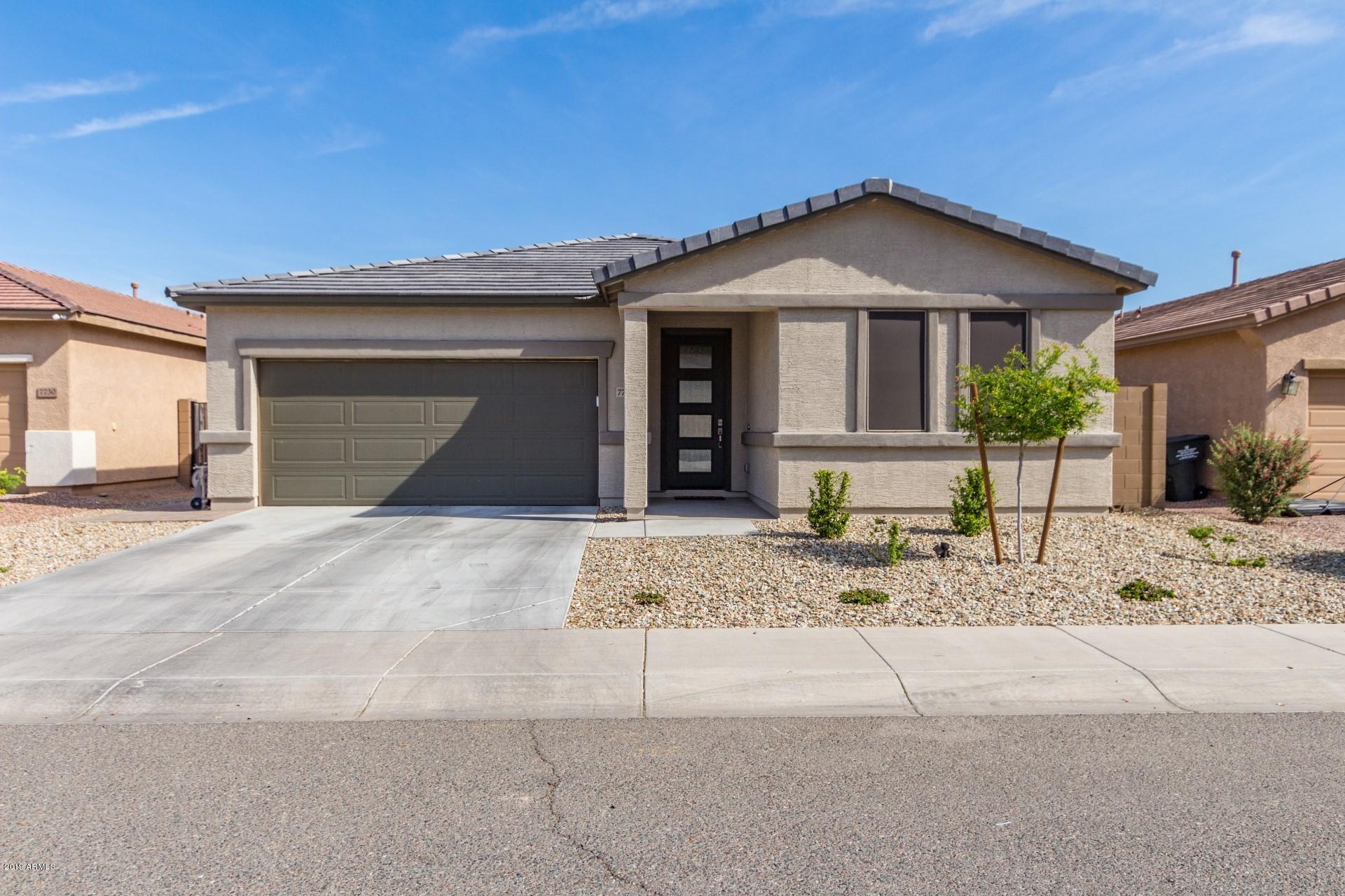 7726 West Shumway Farm Road Laveen, AZ 85339 - Photo 2 of 27 a front view of a house with a yard and garage