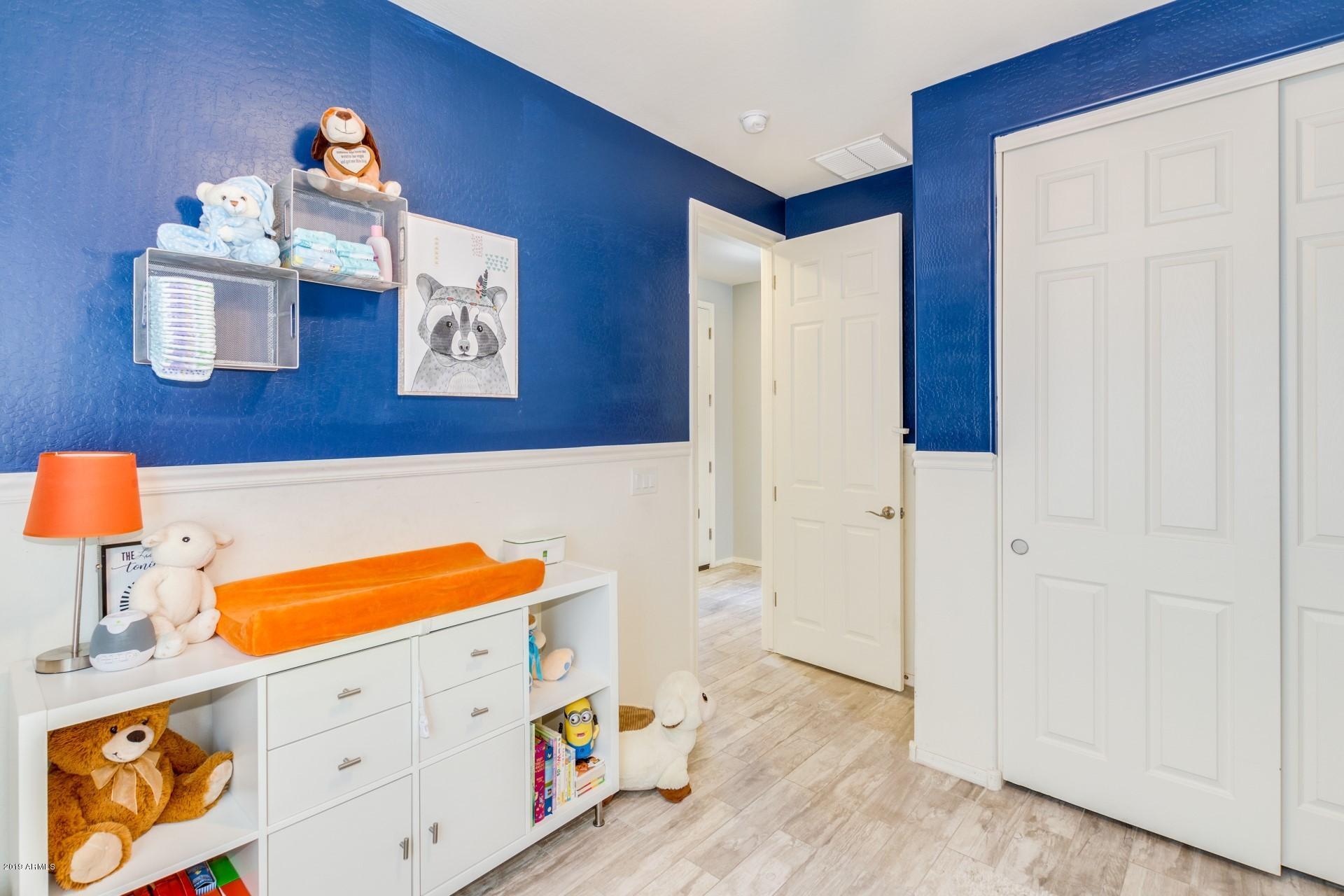 7726 West Shumway Farm Road Laveen, AZ 85339 - Photo 7 of 27 a room with blue wall and painting on the wall
