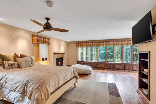 a spacious bedroom with a large bed and a flat tv screen