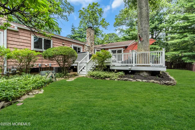 a view of a house with a backyard and deck