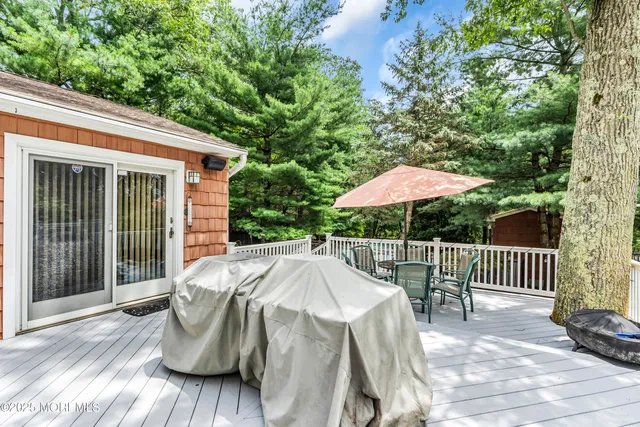 a view of backyard with small deck and wooden floor