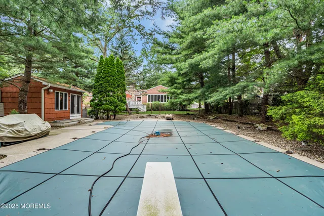 a view of swimming pool with lounge chair and dinning table under an umbrella