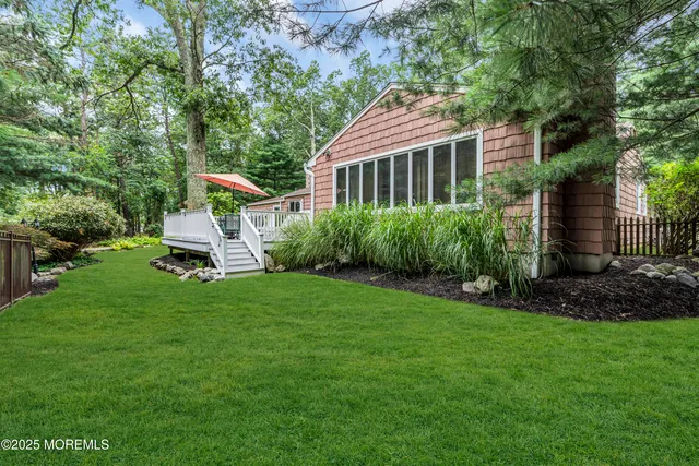a front view of a house with a garden and trees