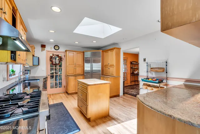 a kitchen with stainless steel appliances granite countertop sink stove and wooden cabinets