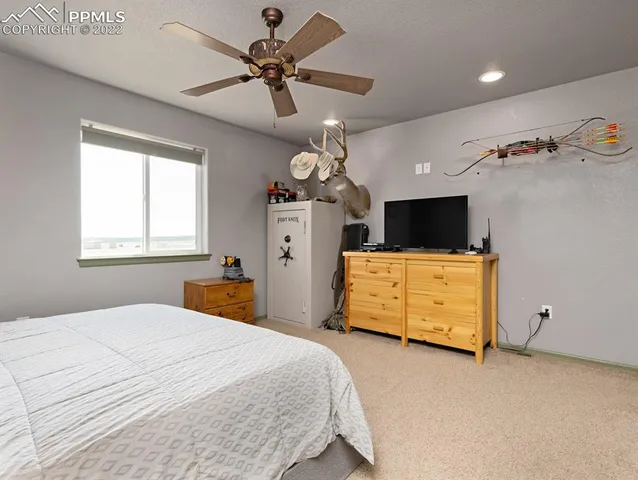 a bedroom with a bed and a flat tv screen on dresser