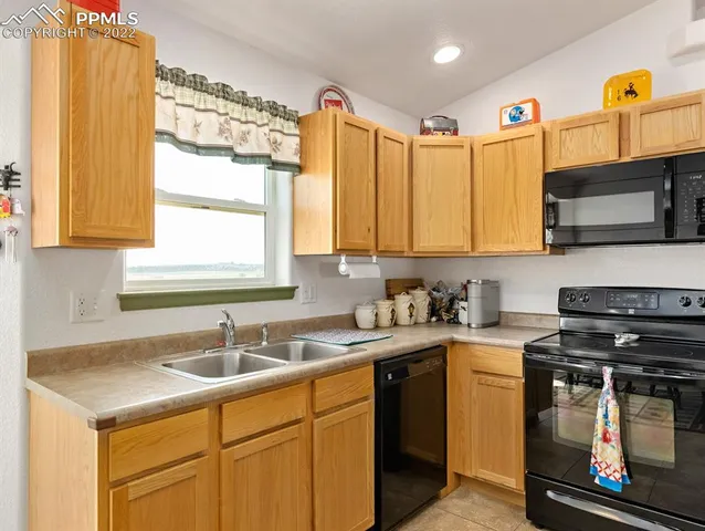 a kitchen with stainless steel appliances a stove a sink a microwave a cabinets and a window