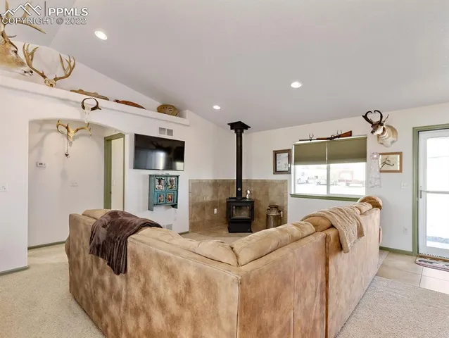 a living room with furniture a flat screen tv and a large window