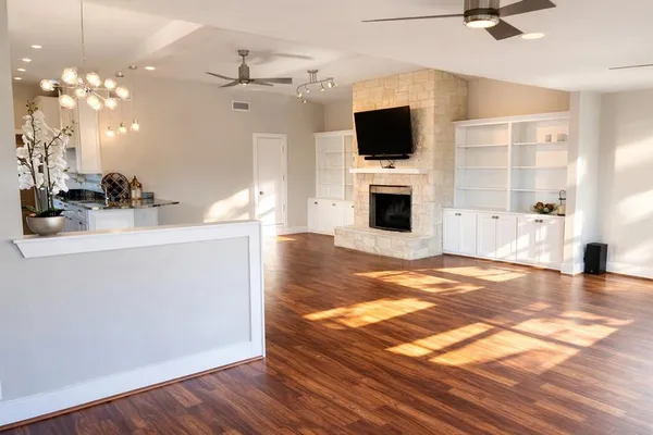 a view of a livingroom with a fireplace a sink and wooden floor