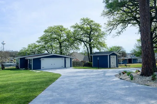 a front view of house with a garden and trees
