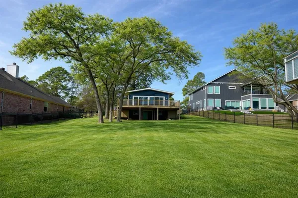 a view of a big house with a big yard and large trees