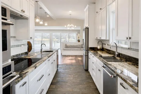 a large kitchen with stainless steel appliances a sink and a stove