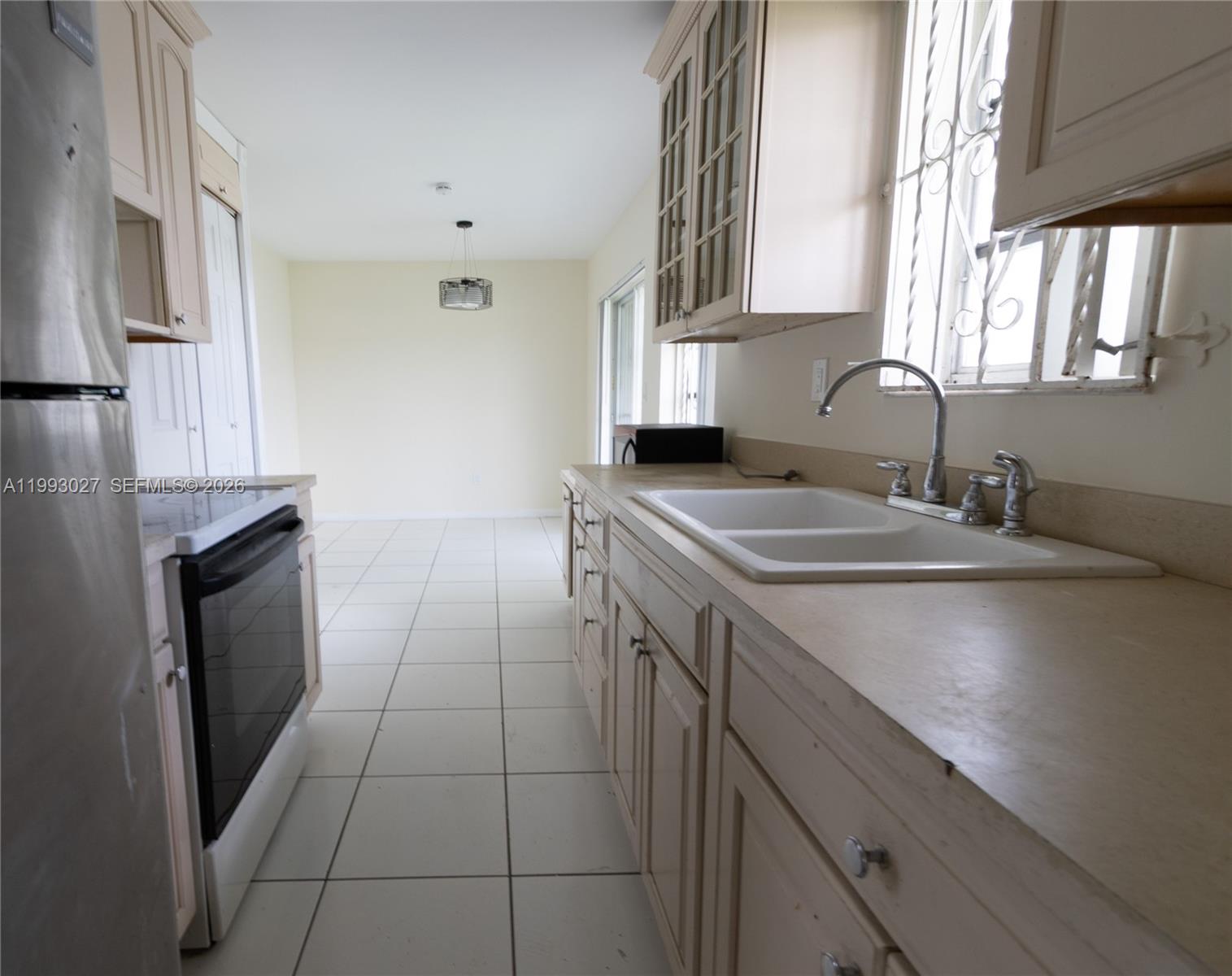 11770 Southwest 168th Street, Unit 11770 Miami, FL 33177 - Photo 14 of 22 a kitchen with a sink cabinets and a window