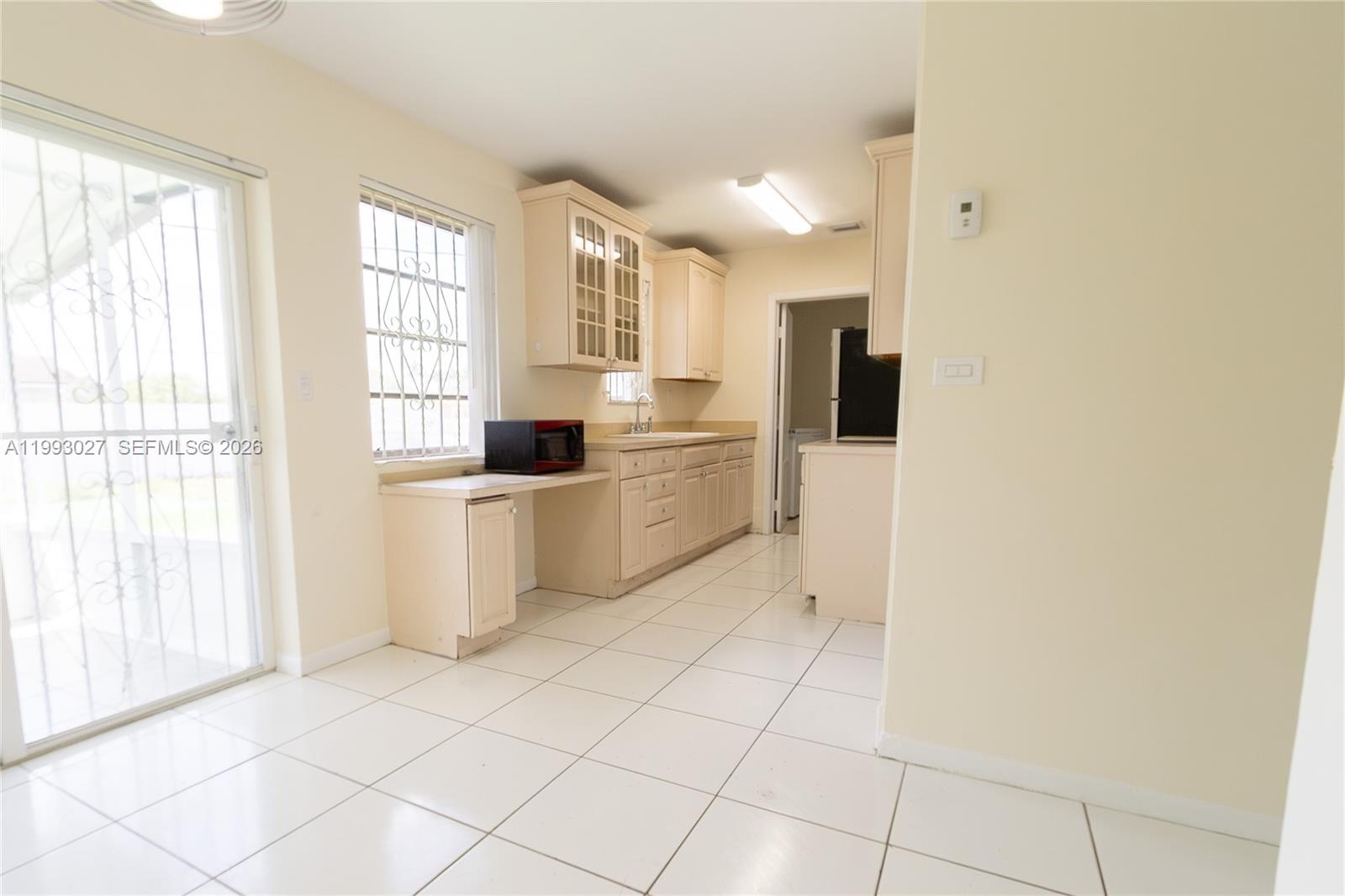 11770 Southwest 168th Street, Unit 11770 Miami, FL 33177 - Photo 16 of 22 a kitchen with white cabinets and window