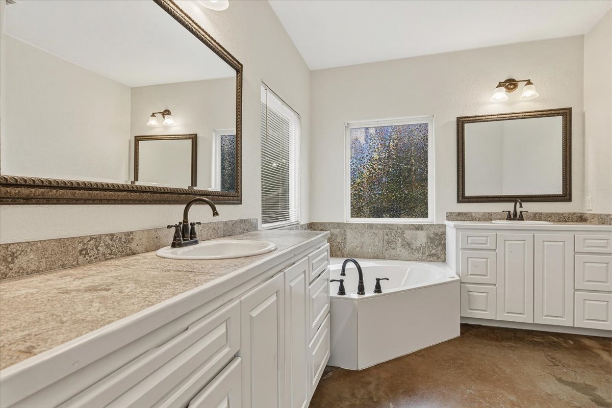 207 Cardinal Loop Paige, TX 78659 - Photo 16 of 39 a bathroom with a granite countertop tub sink and mirror