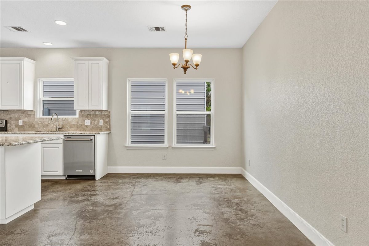 207 Cardinal Loop Paige, TX 78659 - Photo 9 of 39 a view of a kitchen with a sink cabinet and a chandelier