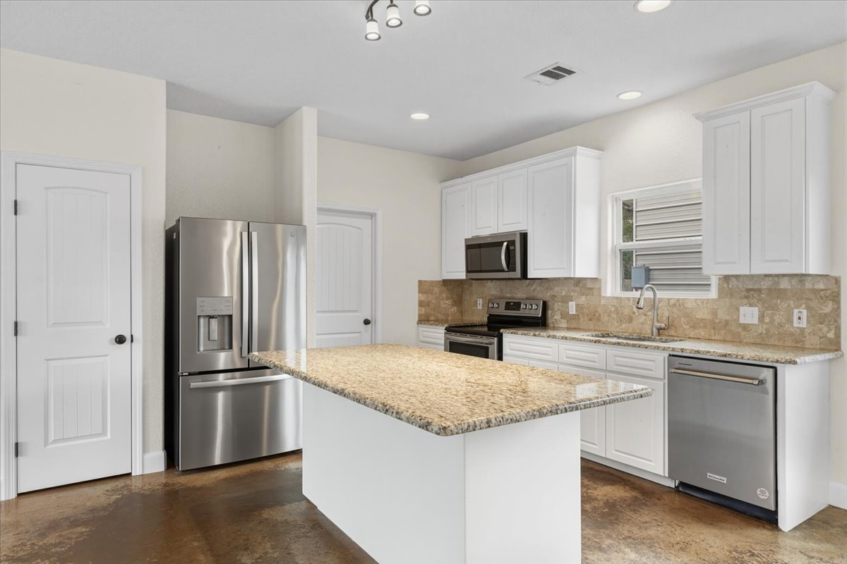 207 Cardinal Loop Paige, TX 78659 - Photo 10 of 39 a kitchen with granite countertop a refrigerator and a sink