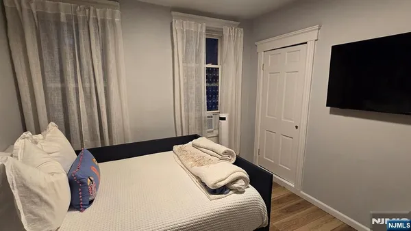 a bedroom with a bed and a flat tv screen