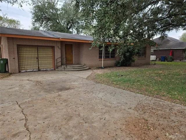 a front view of a house with a garden and trees
