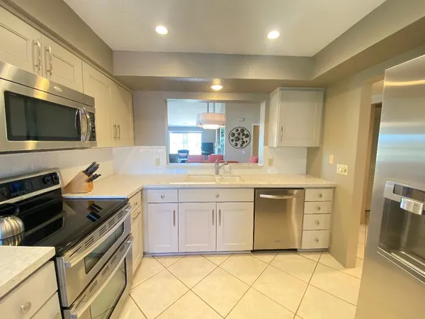 a kitchen with white cabinets and appliances