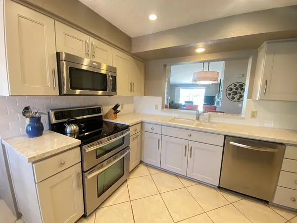 a kitchen with cabinets stainless steel appliances and a sink