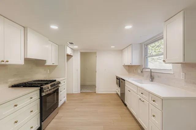 a kitchen with granite countertop white cabinets and white appliances