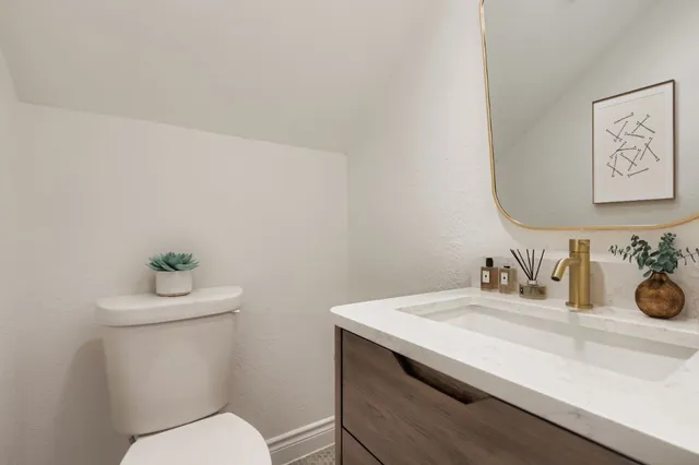 a bathroom with a sink mirror and toilet