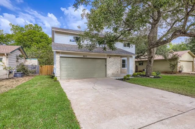 front view of a house with a yard and an trees