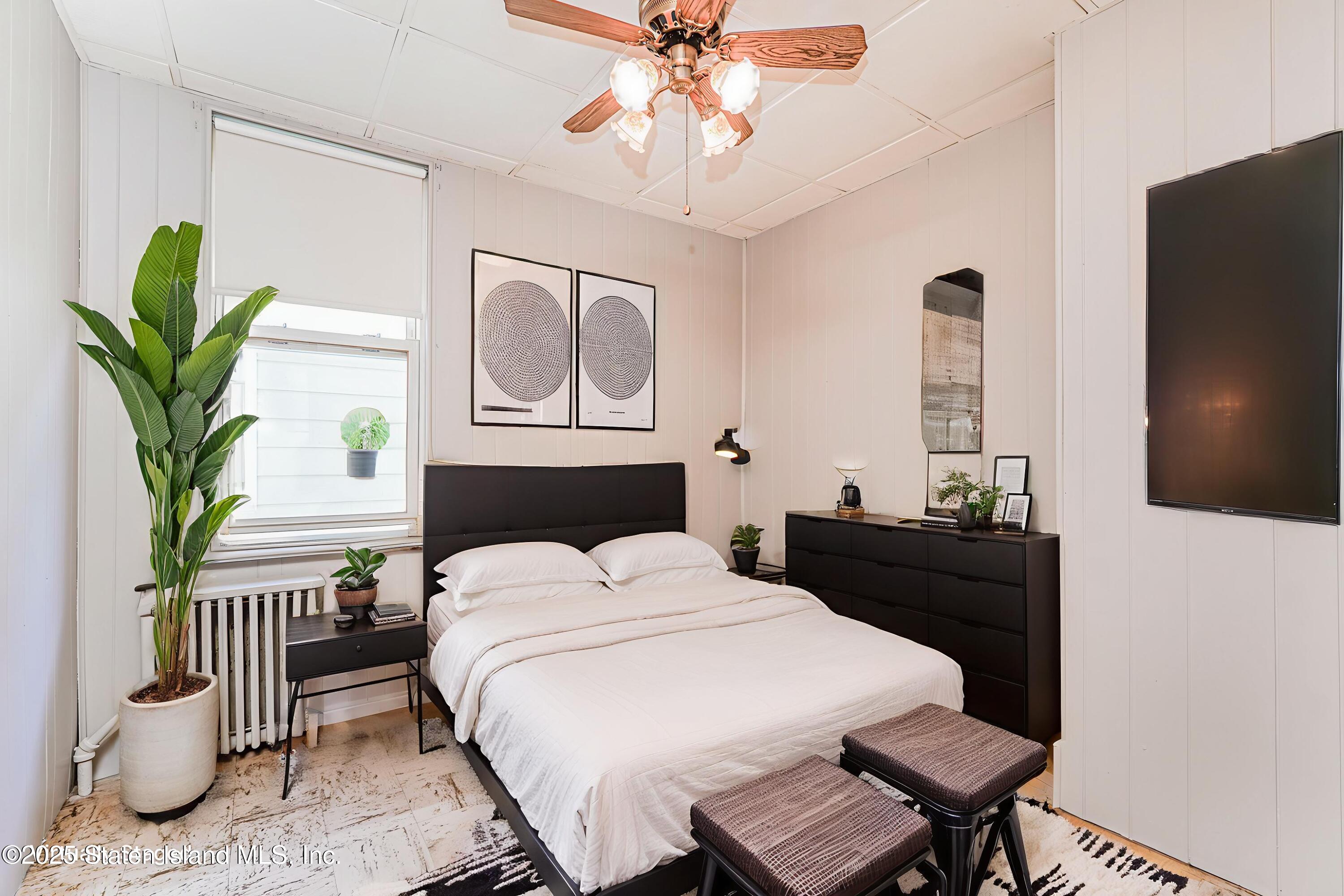 230 Fillmore Street Staten Island, NY 10301 - Photo 19 of 37 a bedroom with a bed table and a chandelier