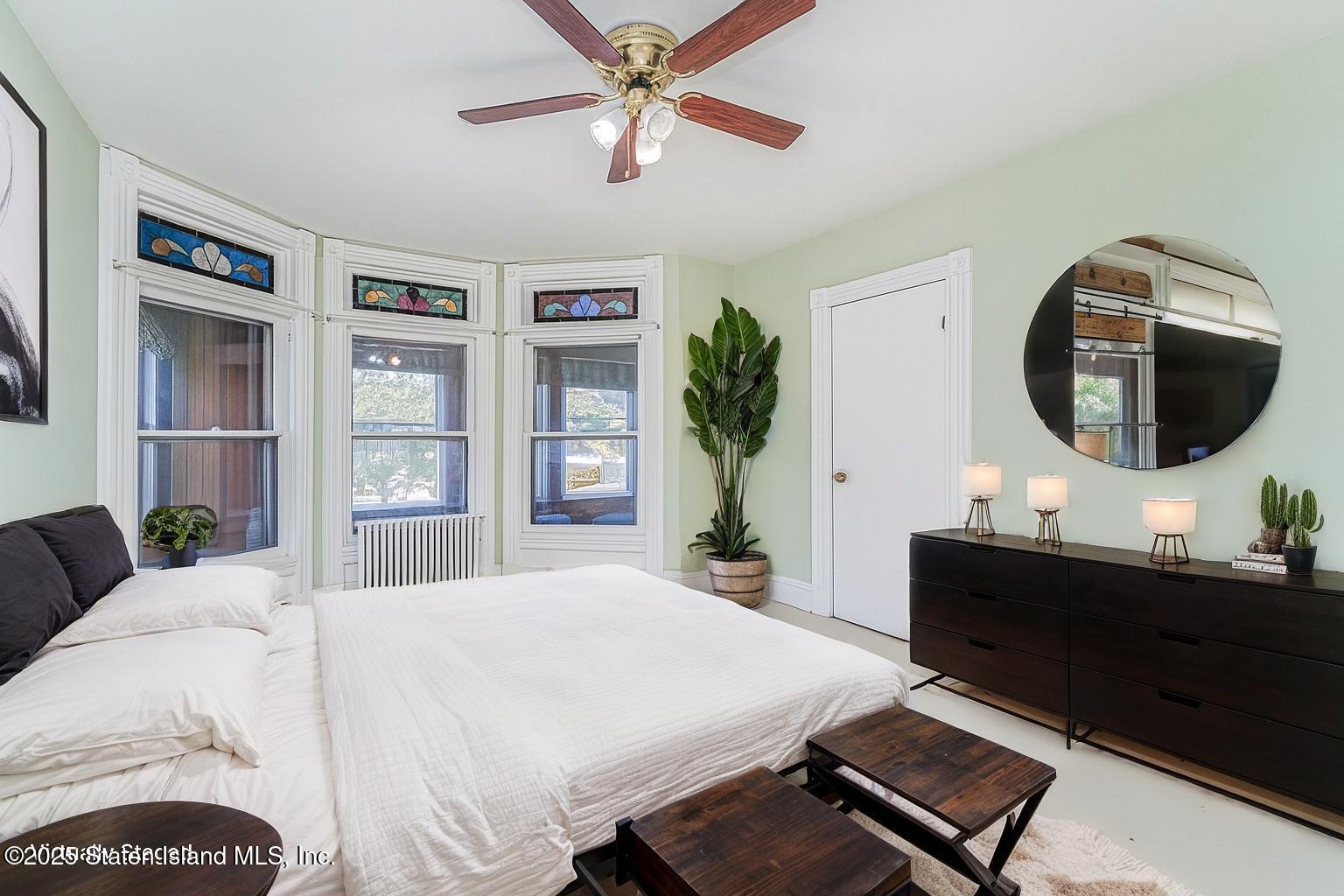 230 Fillmore Street Staten Island, NY 10301 - Photo 6 of 37 a bedroom with a large bed and a chandelier