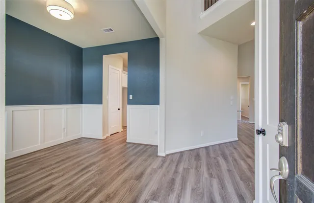 a view of an empty room with wooden floor