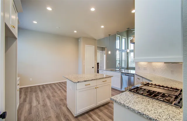 a kitchen with a sink stove and cabinets