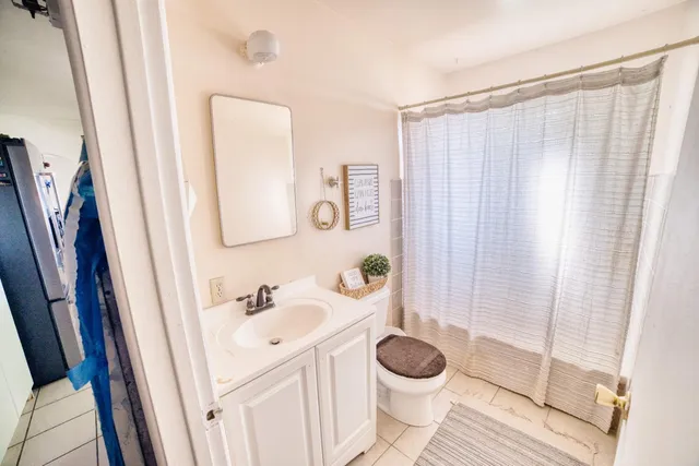 a bathroom with a sink a toilet and shower curtain