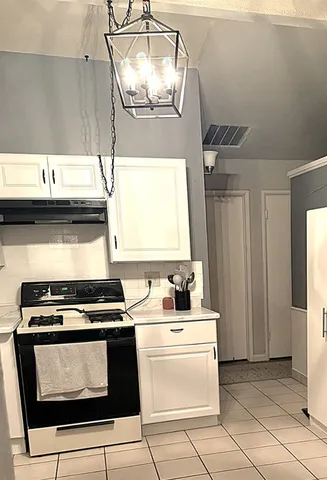 a kitchen with kitchen island a stove a sink and a microwave