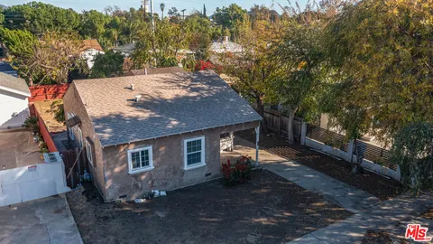 a view of a house with a yard and large tree