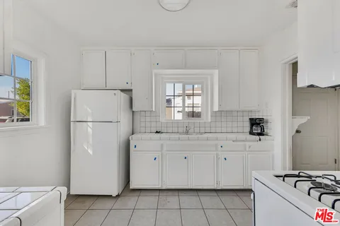 a kitchen with white cabinets and white appliances