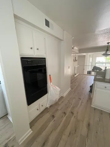 a living room with stainless steel appliances wooden floor and fireplace