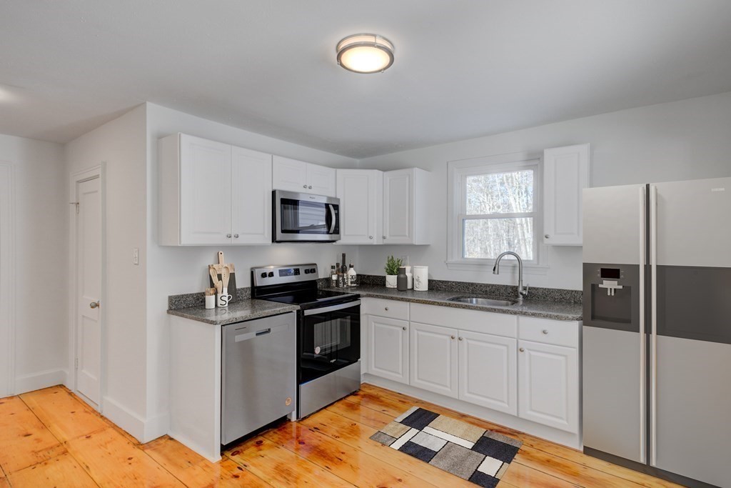 4 Highland Street Townsend, MA 01469 - Photo 4 of 14 a kitchen with granite countertop a sink stove and cabinets