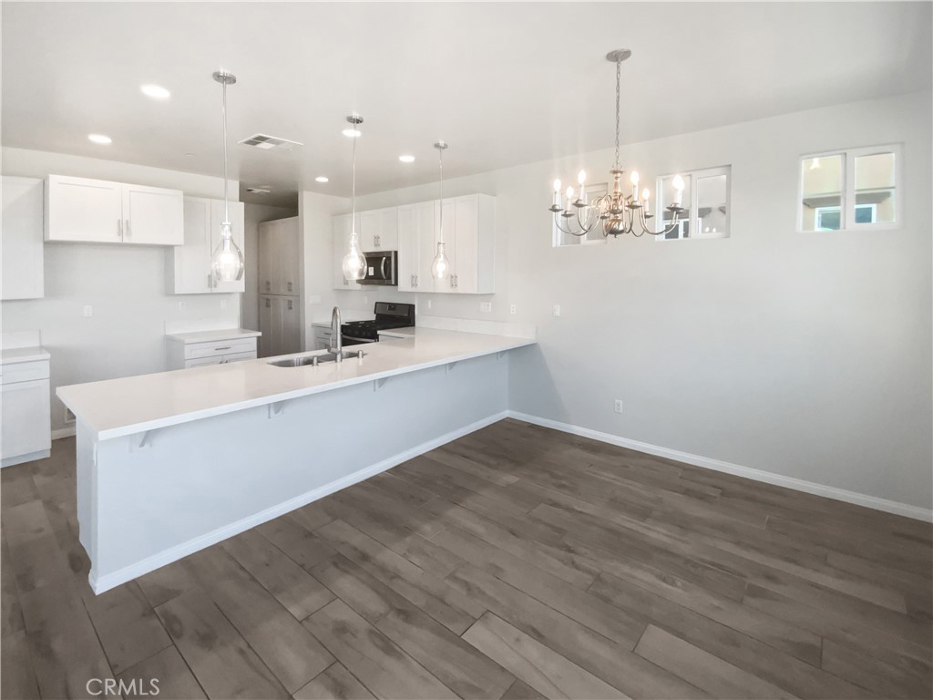 12420 Tesoro Court Grand Terrace, CA 92313 - Photo 14 of 43 a kitchen with a sink cabinets and wooden floor