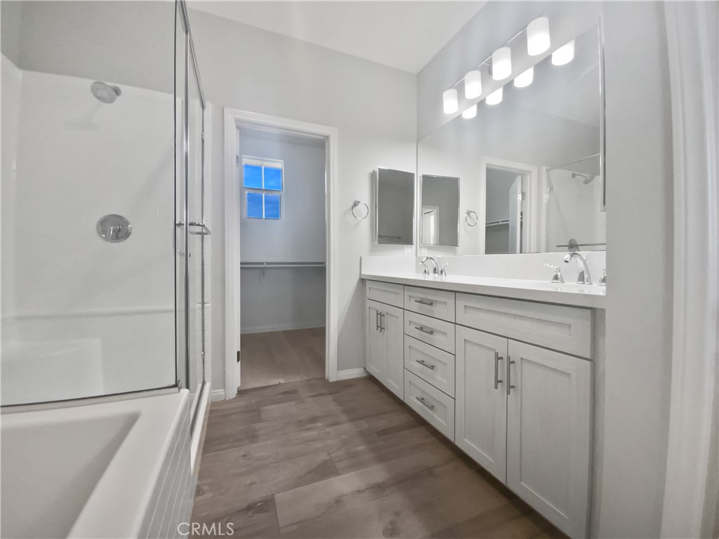 12420 Tesoro Court Grand Terrace, CA 92313 - Photo 33 of 43 a bathroom with a double vanity sink a mirror and a shower