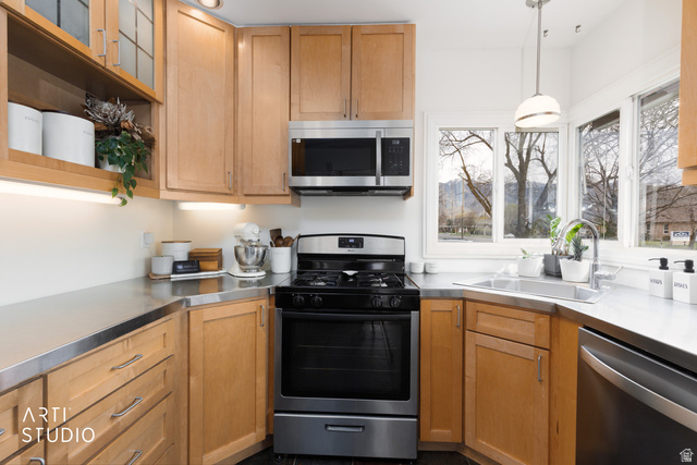 265 West 200 North Logan, UT 84321 - Photo 8 of 31 Kitchen with stainless steel countertops, stainless steel appliances, open shelves, decorative light fixtures, and glass fronted cabinets