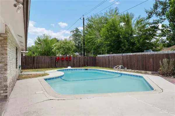 a view of a backyard with swimming pool and outdoor seating